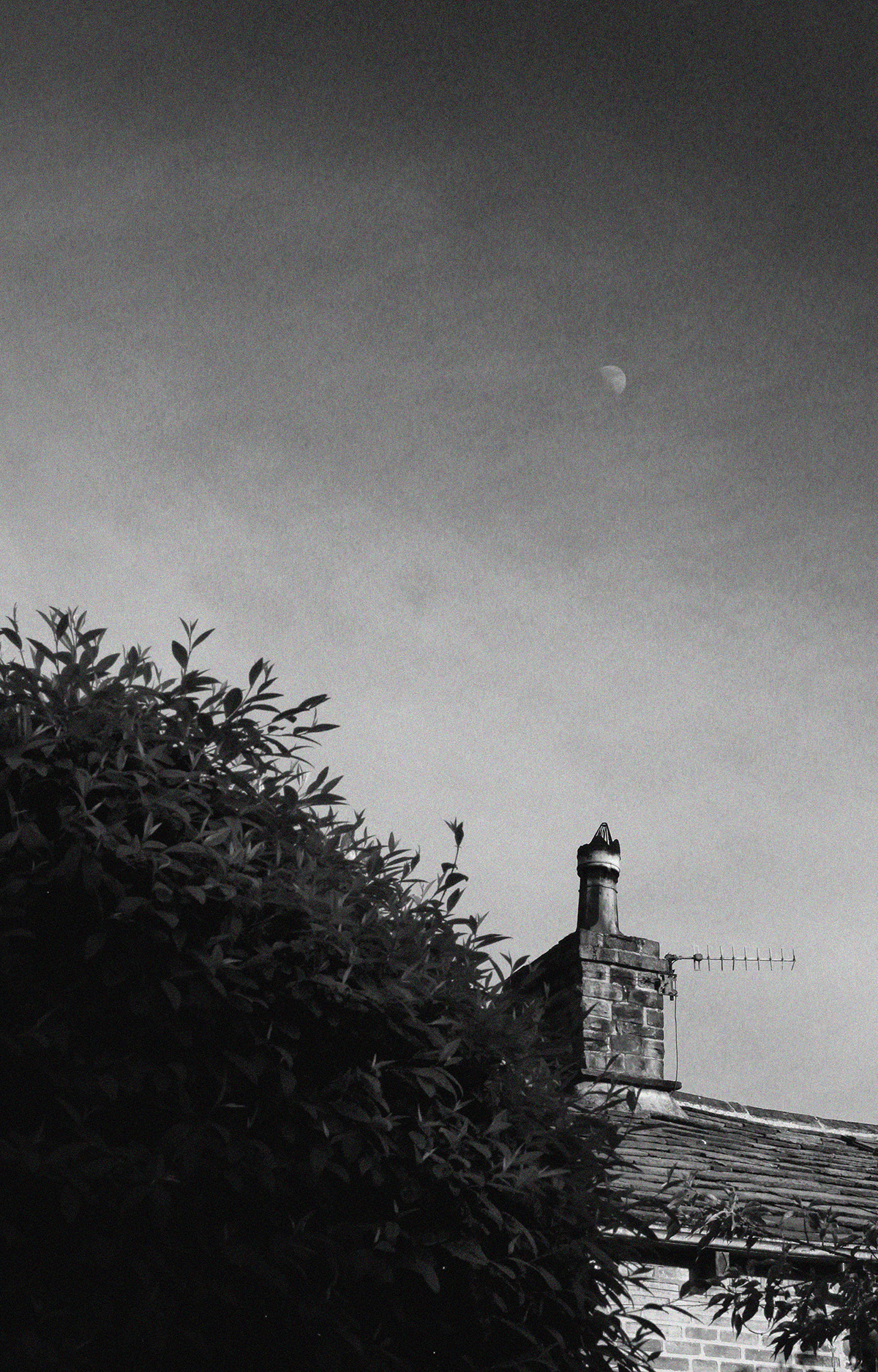 Moon Over Terrace Chimney - Black and white picture of the moon in the sky above the chimney of a terrace house - photo by gavstretchy